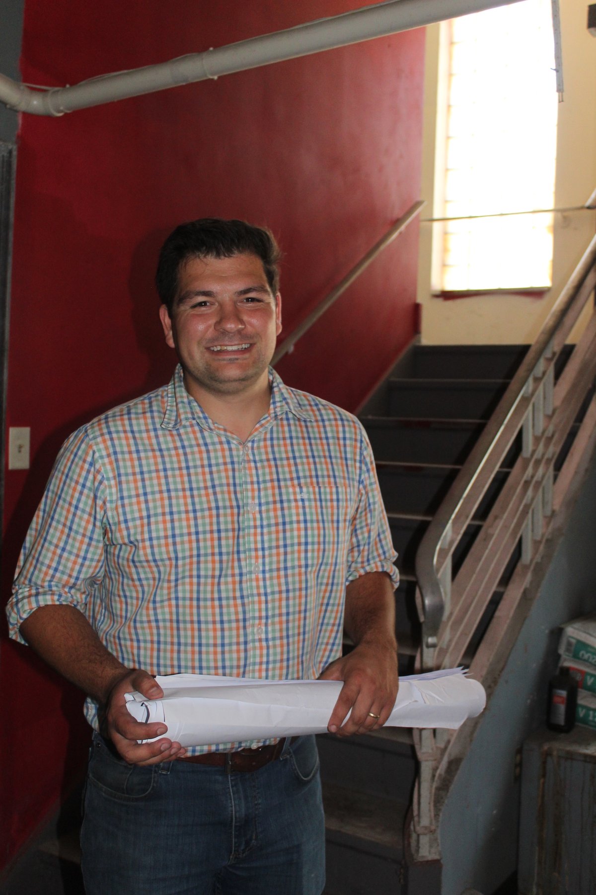 Andrew Sharples, Founder of Oyo Brewing Co., holding building plans inside the stairwell of 338 Market Street